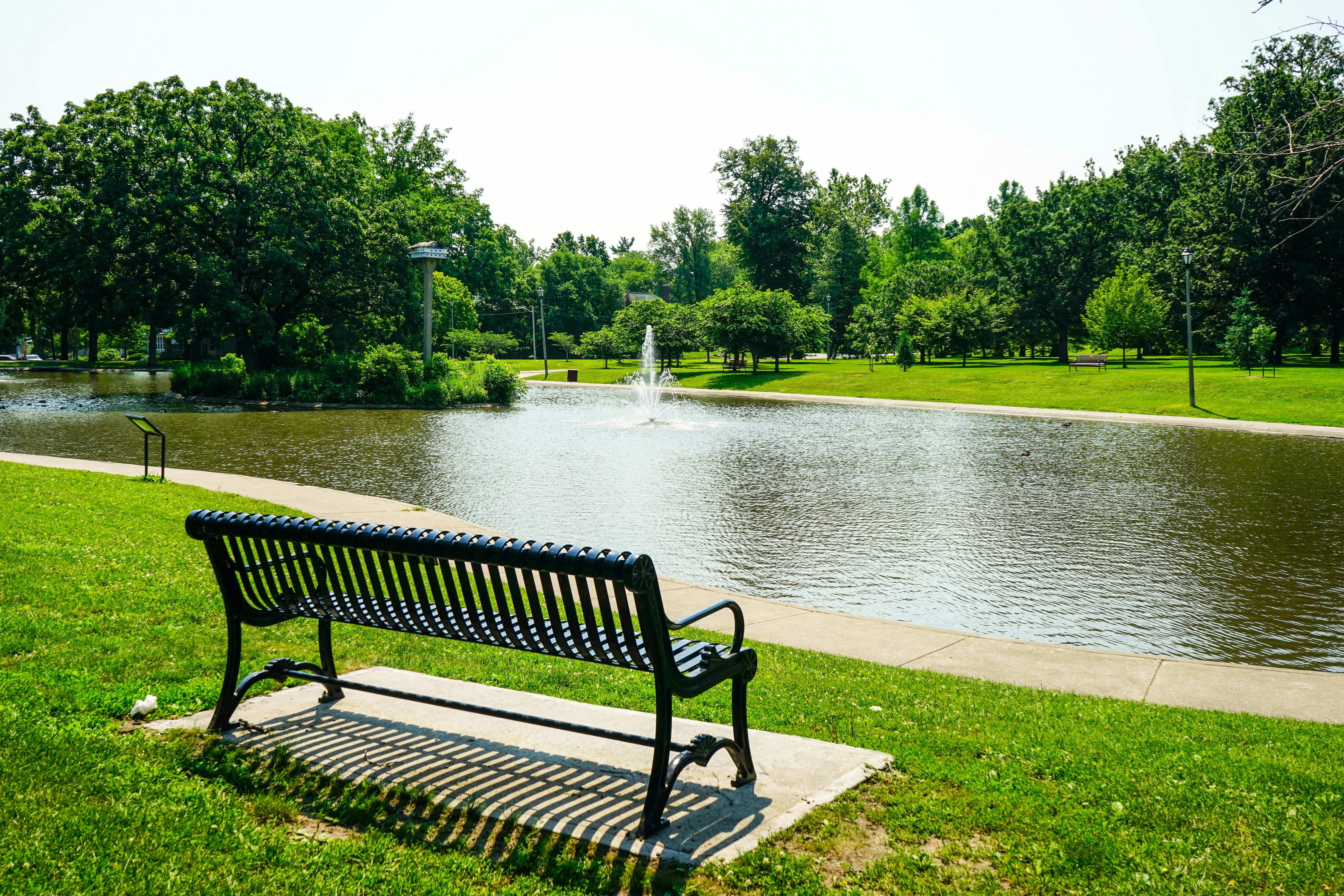 black metal bench near lake during daytime
